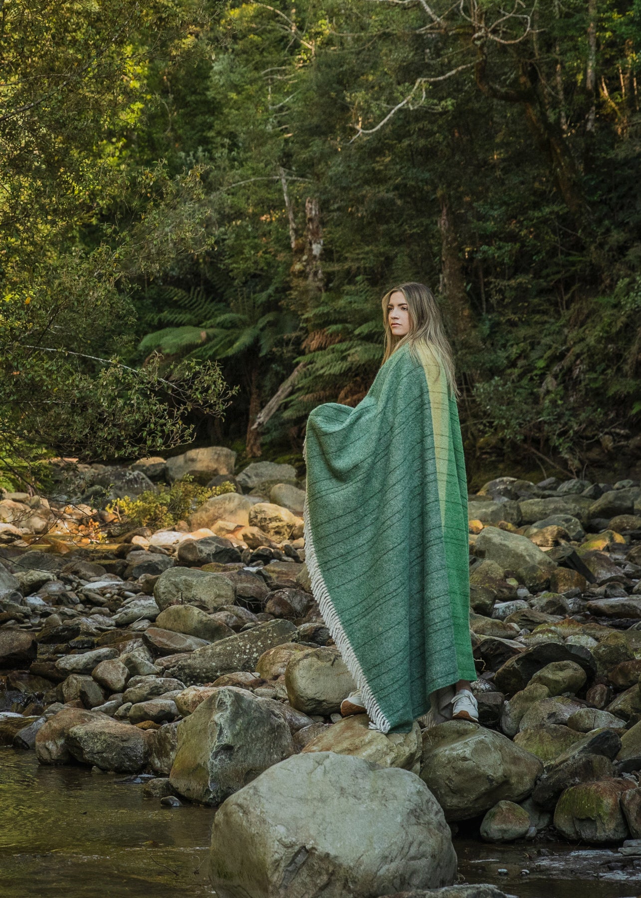 A girl wrapped in the Tarkine Forest throw standing in the Tarkine forest.