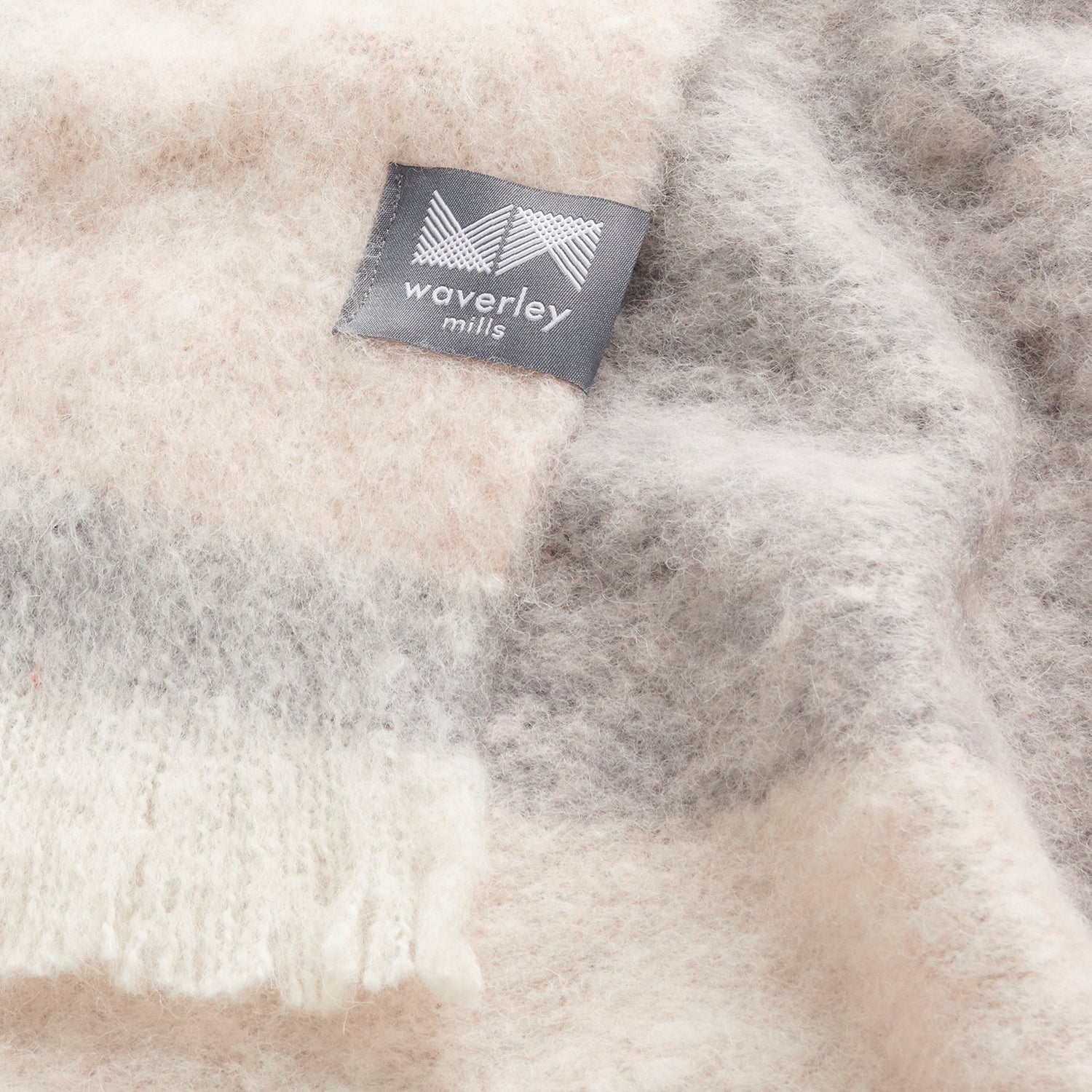 A close up of a pink ombre throw showing the texture of the fabric and subtle colouration.