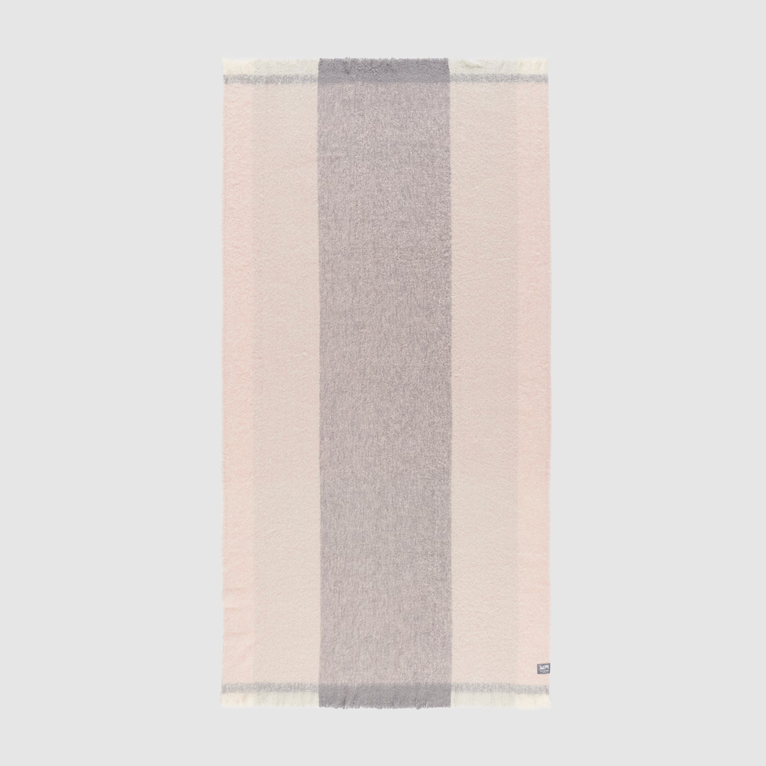 A full view of a pink ombre alpaca throw showing the striped geometric pattern.