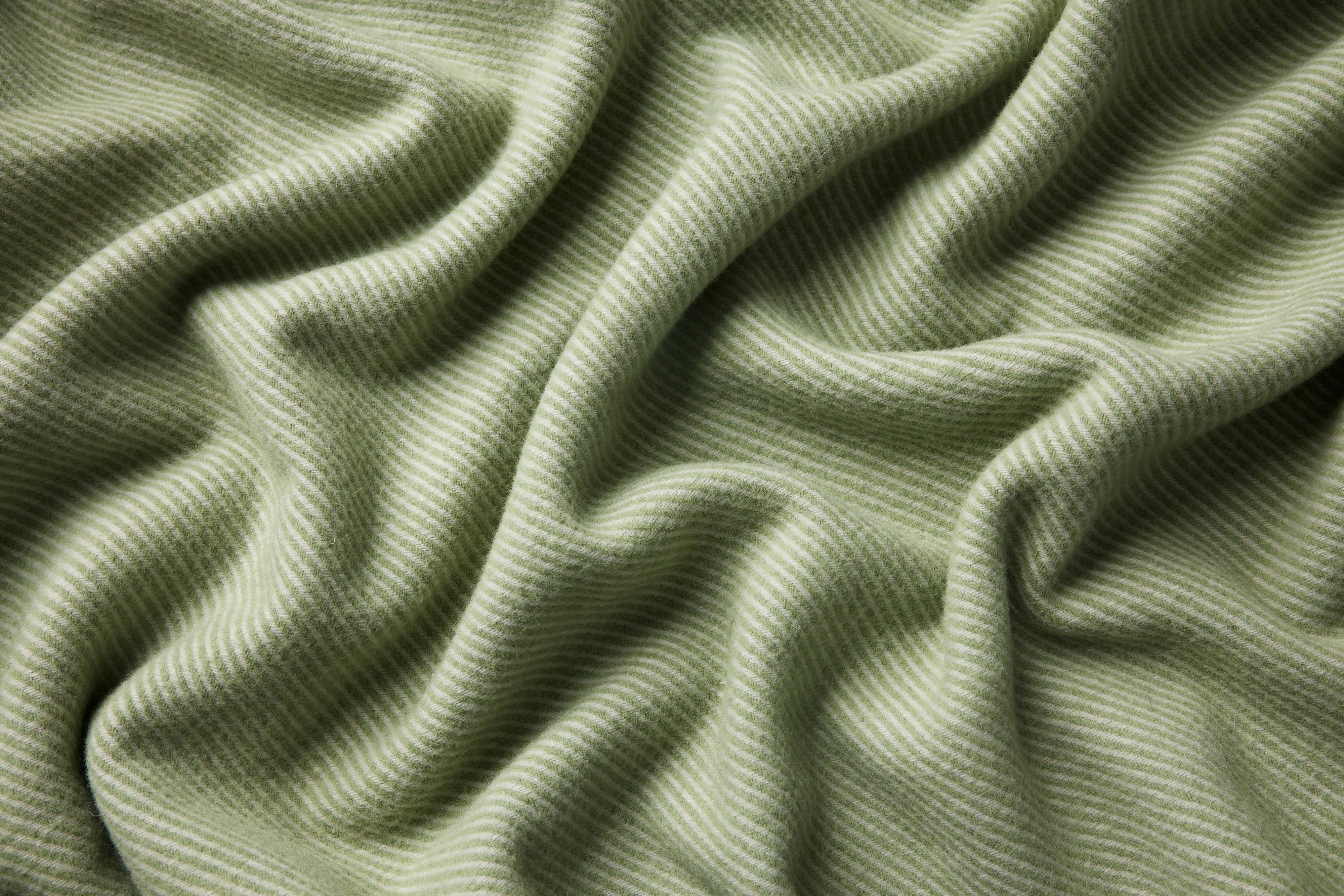 Close up of a flint blanket in moss showing the contrasting twill weave and drape.