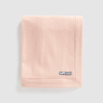 Folded merino wool baby blanket nest in pink.