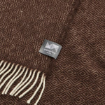 A close up of a chocolate knee rug with a diamond pattern.