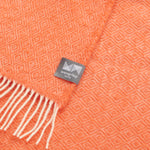 A close up of an emberglow orange knee rug with a diamond pattern.