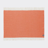 A full view of a diamond patterned emberglow orange knee rug.