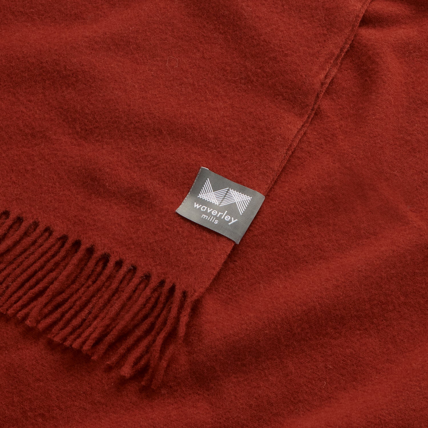 Close up of an essential throw in desert red.
