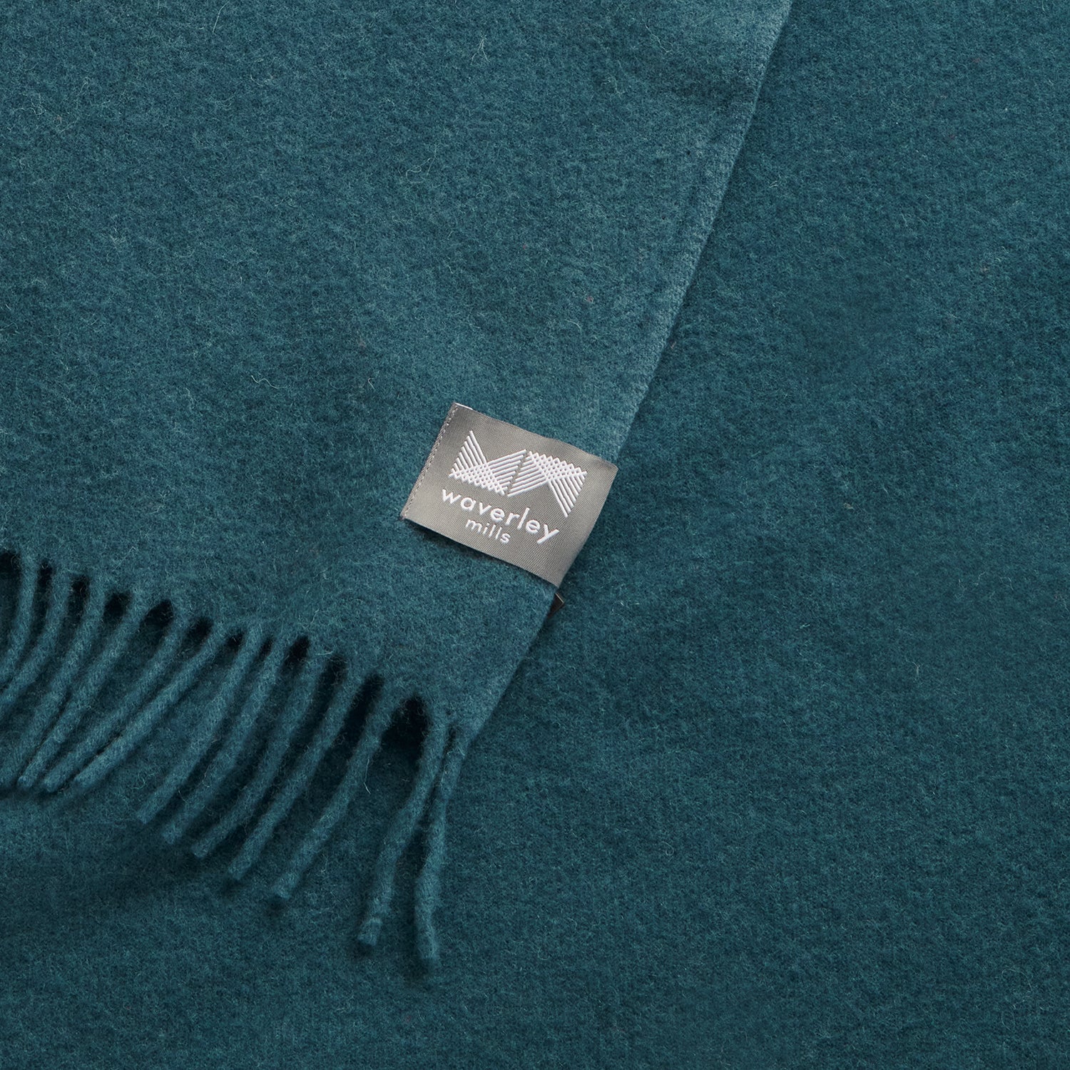 Close up of an essential throw in solid teal.