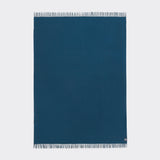 Full view of an essential throw in solid teal.