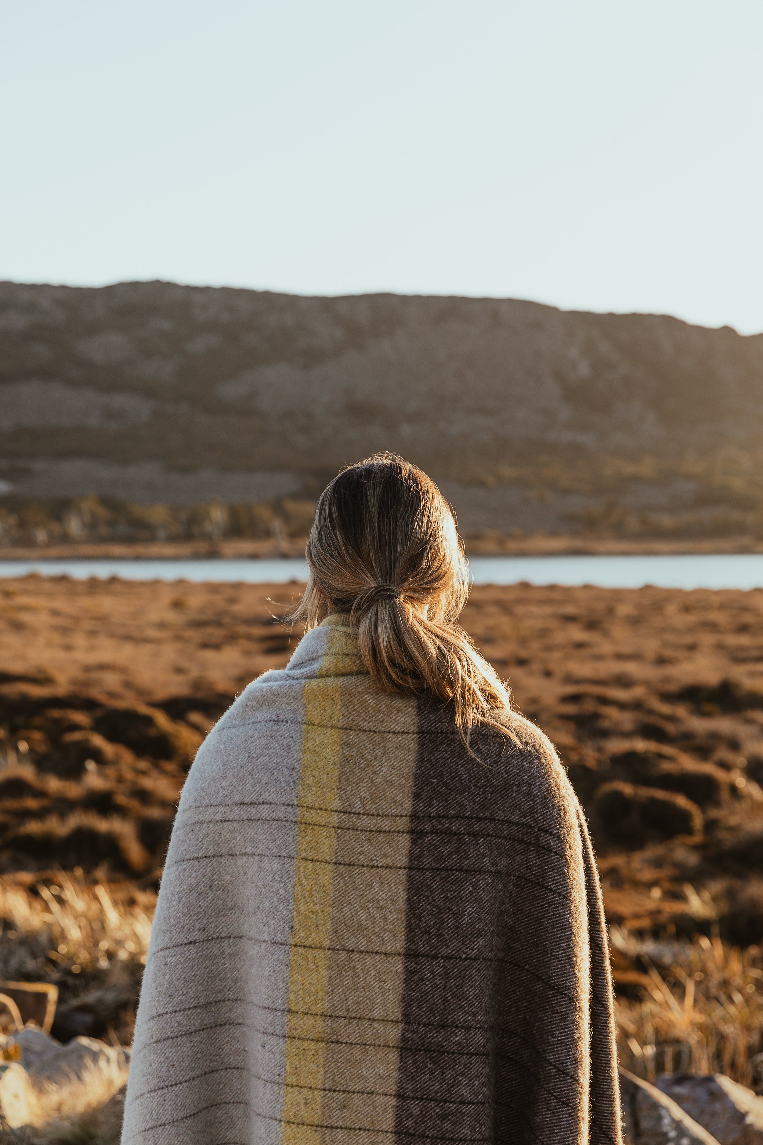 A girl with the Cradle Mountain throw over her shoulders.