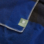 A close up of a seafarer check travel rug in black and blue.