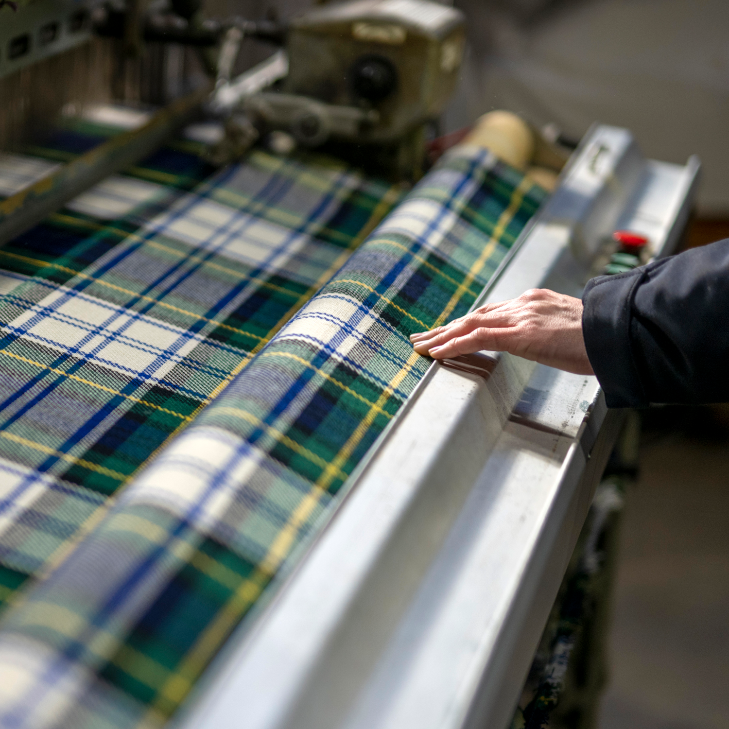 A team member checks on a loom.