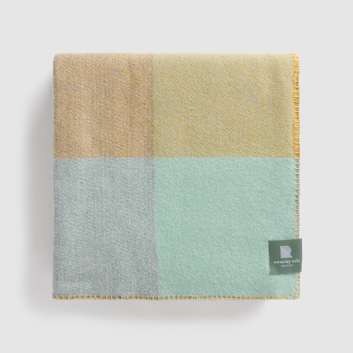 A folded chequer blanket in gold and baby blue checks.
