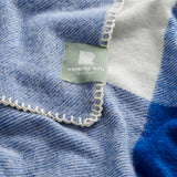 A close up of the seafarer check blanket showing the natural whip stitch edge.
