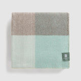 A folded chequer blanket in mint and grey.