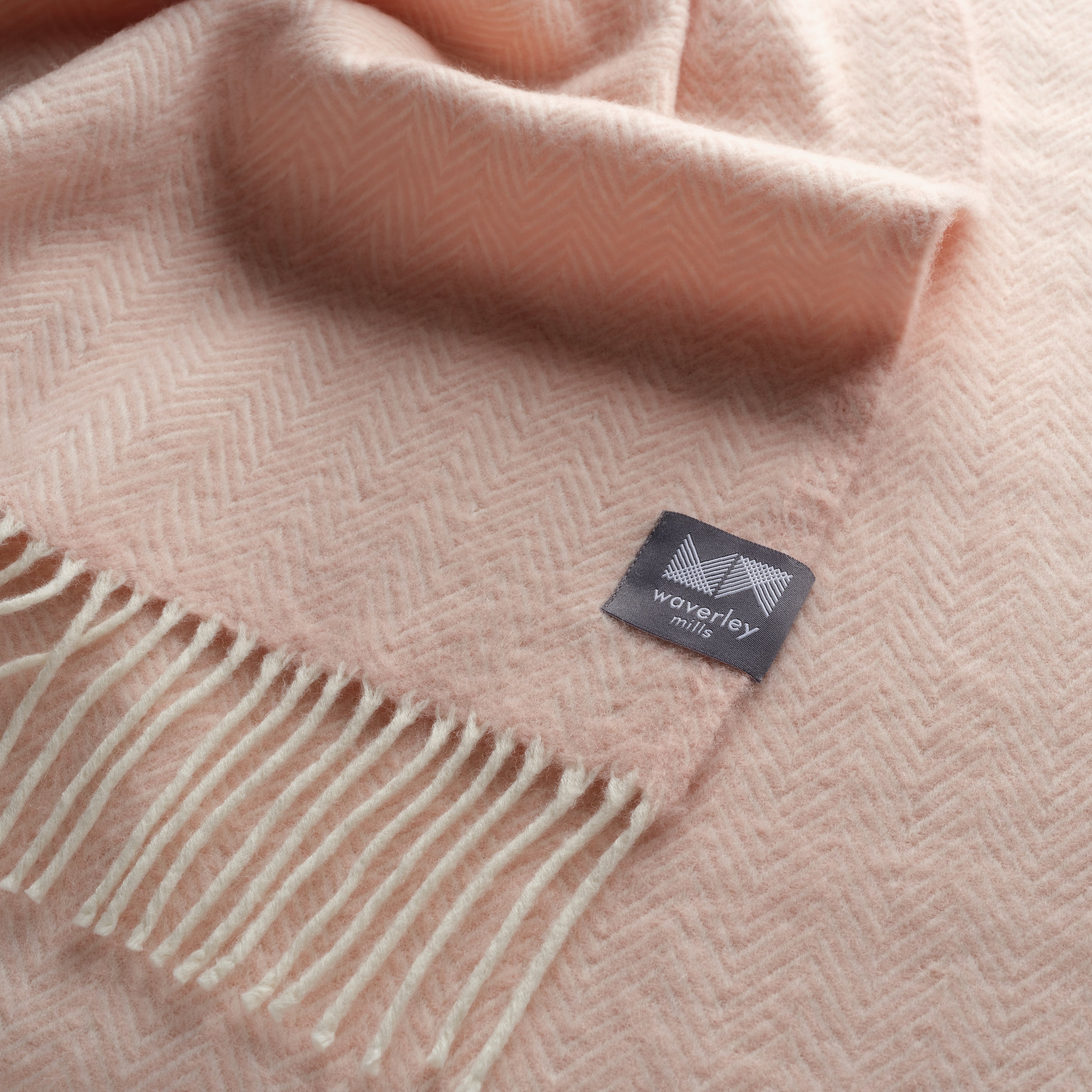 Close up of a cameo pink herringbone throw.