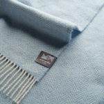 Close up of sky blue herringbone throw.