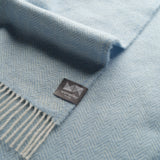 Close up of sky blue herringbone throw.