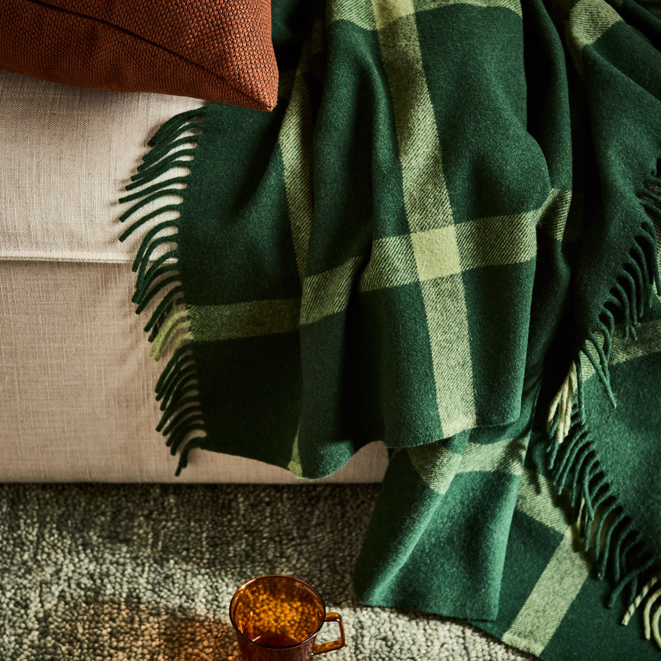 Ravine throw in forest draped over a sofa.