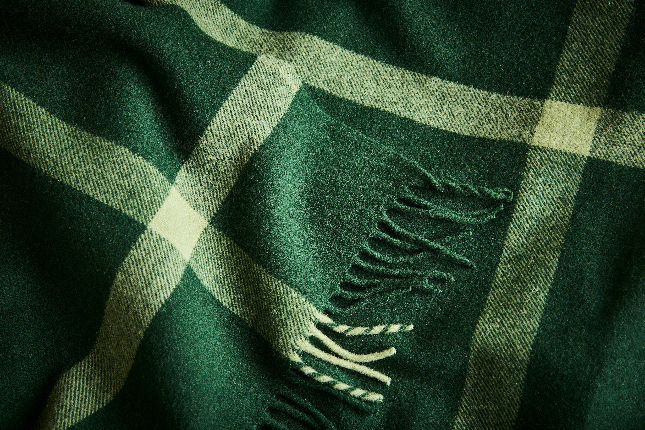Close up of 100% merino wool throw Ravine in forest.