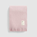 Folded cooper's cormo throw in mauve.
