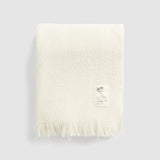 Folded cooper's cormo throw in natural.
