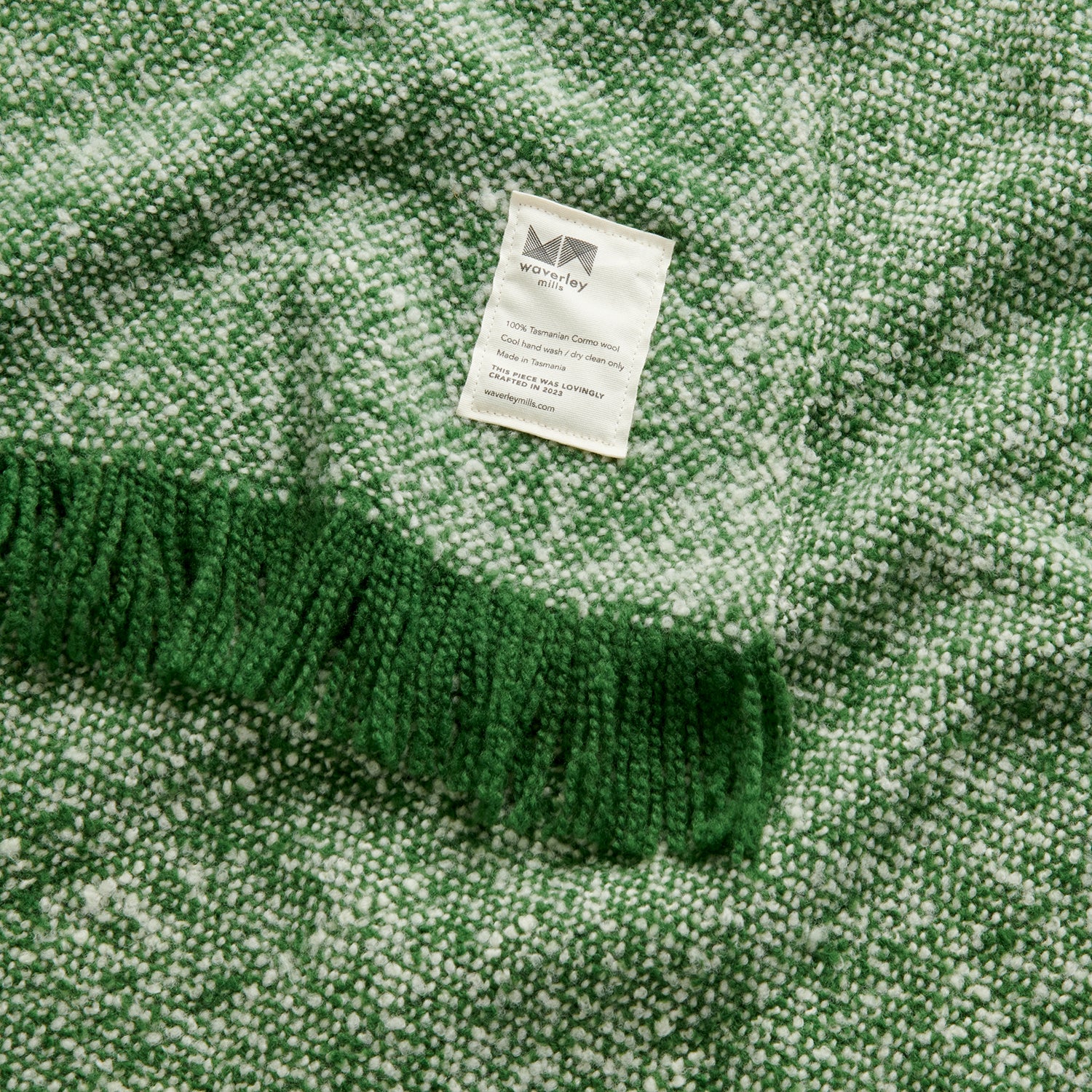 Close up of cooper's cormo throw in artichoke green and natural.