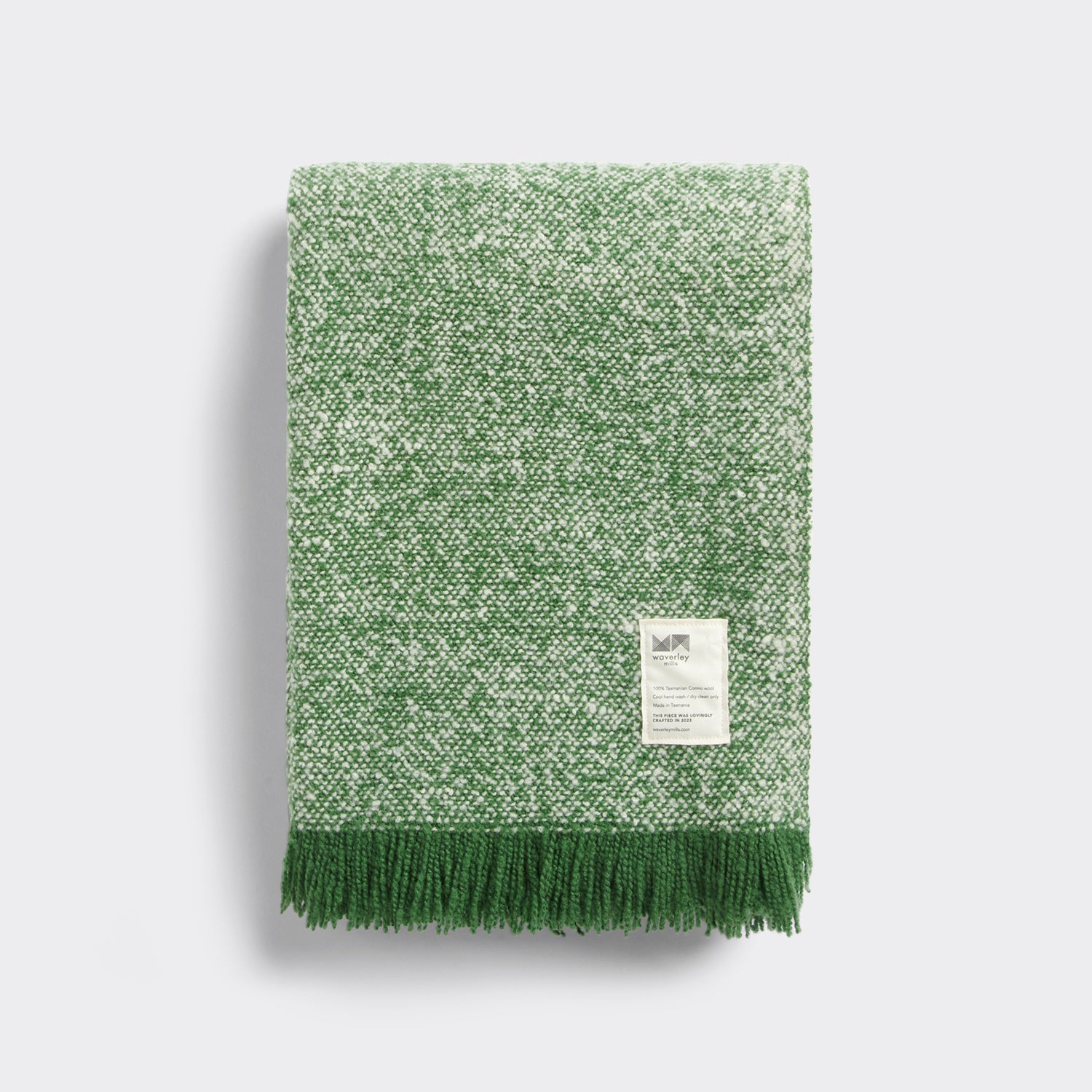 Folded cooper's cormo throw in artichoke green and natural.