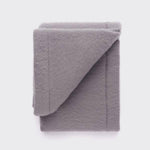 Folded grey baby blanket.