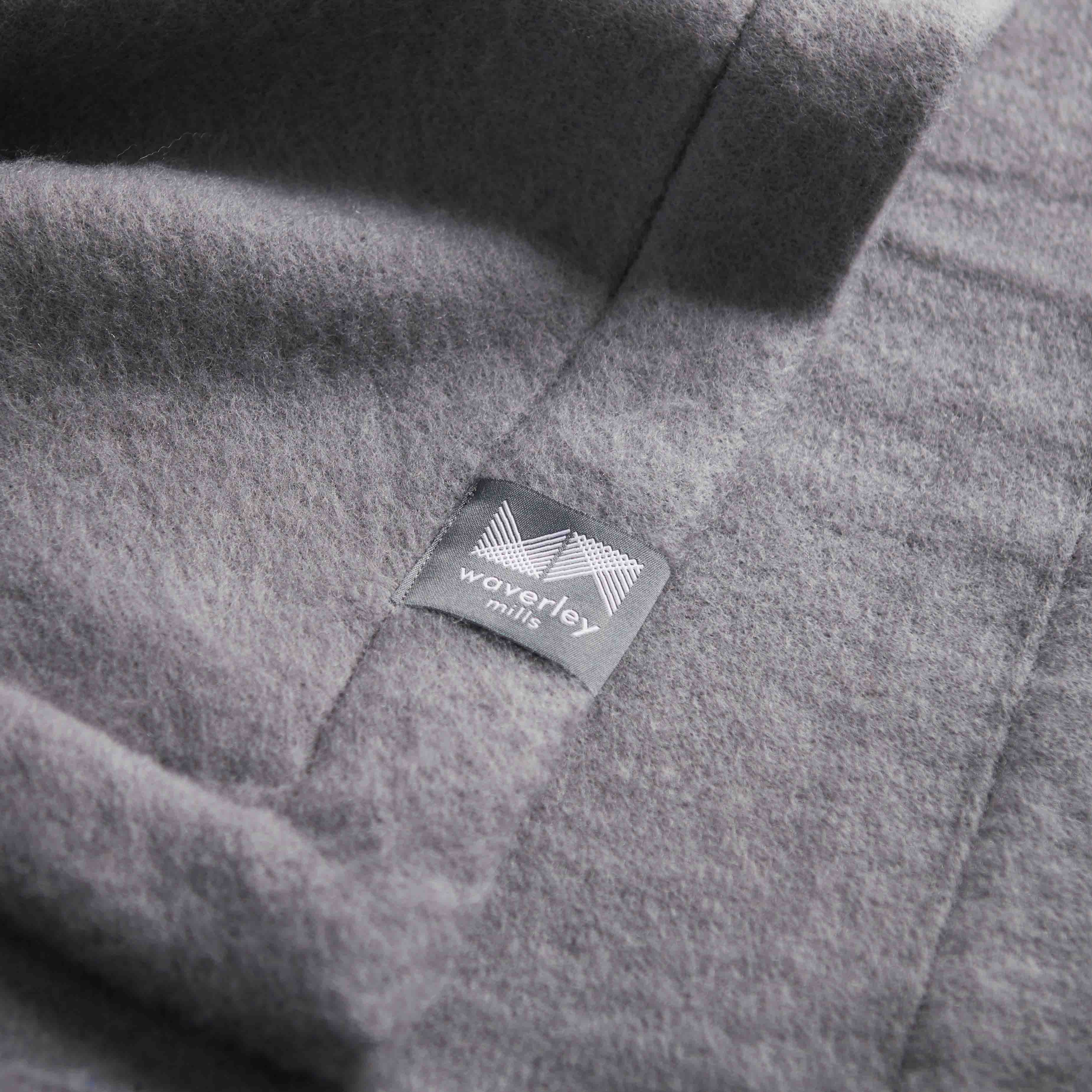 Close up of grey baby blanket showing channel stitched edge.