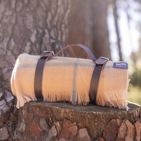 A modern heritage throw in tan with a leather carrier.