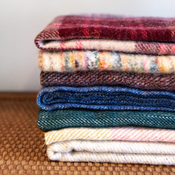 A stack of woollen and made-made fibre fabrics.