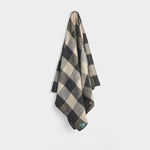 Draped Kingsway Check travel rug in black and beige.