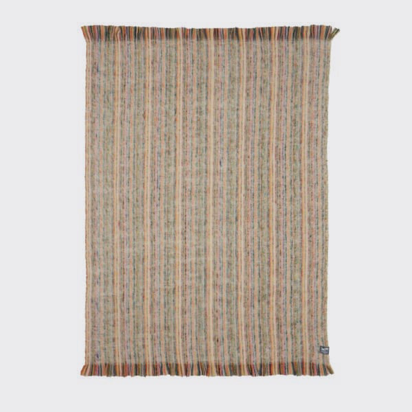 Full view of the multicolour alpaca throw showing colour variation against a natural weft.