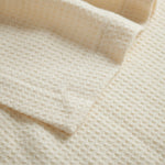 Close up of merino wool waffle baby blanket with cot stitch edge.