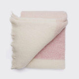 Folded alpaca stripe throw in shades of pink and natural.