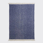 Full view of navy alpaca throw showing contrast natural fringe.