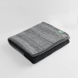 Folded tonal travel rug in black and grey.