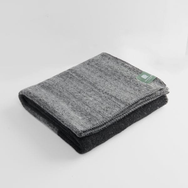 Folded tonal travel rug in black and grey.