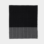 Full view of tonal travel rug in black and grey.